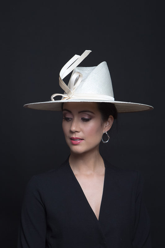 The Cream Fedora with Sweeping Bow is a modern fedora with a high angular concave crown and a sweeping wide brim