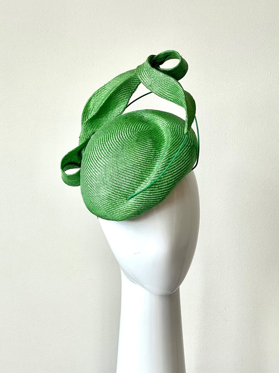 The Green Side Beret with Sculptured Leaves is a two-tiered beret Trimmed with sculptured looped leaves in the same fine weave straw.