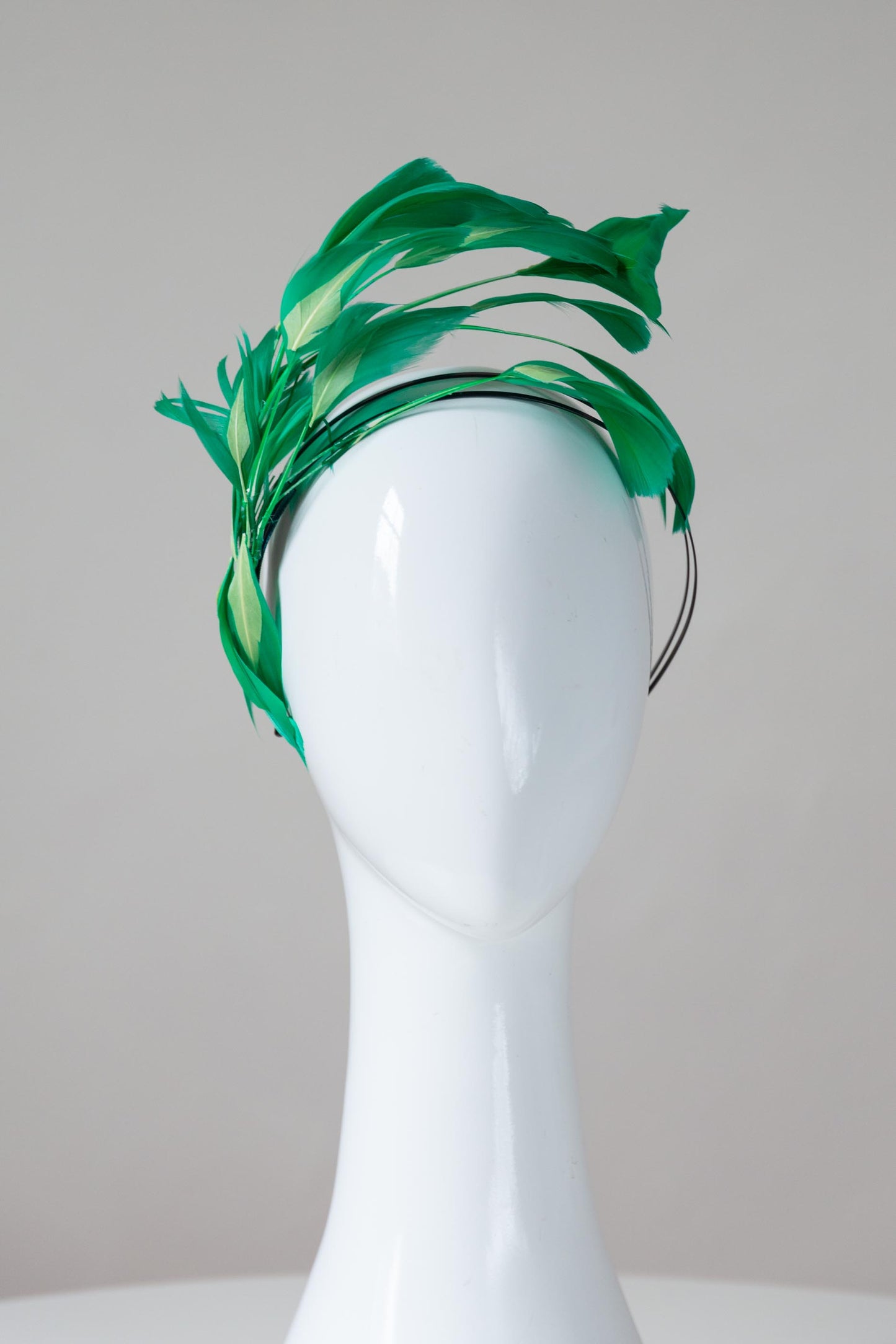 The Floating Two-Toned Green Feathered Headband features sweeping feathers in grass green which are inlaid with soft lime green highlights.