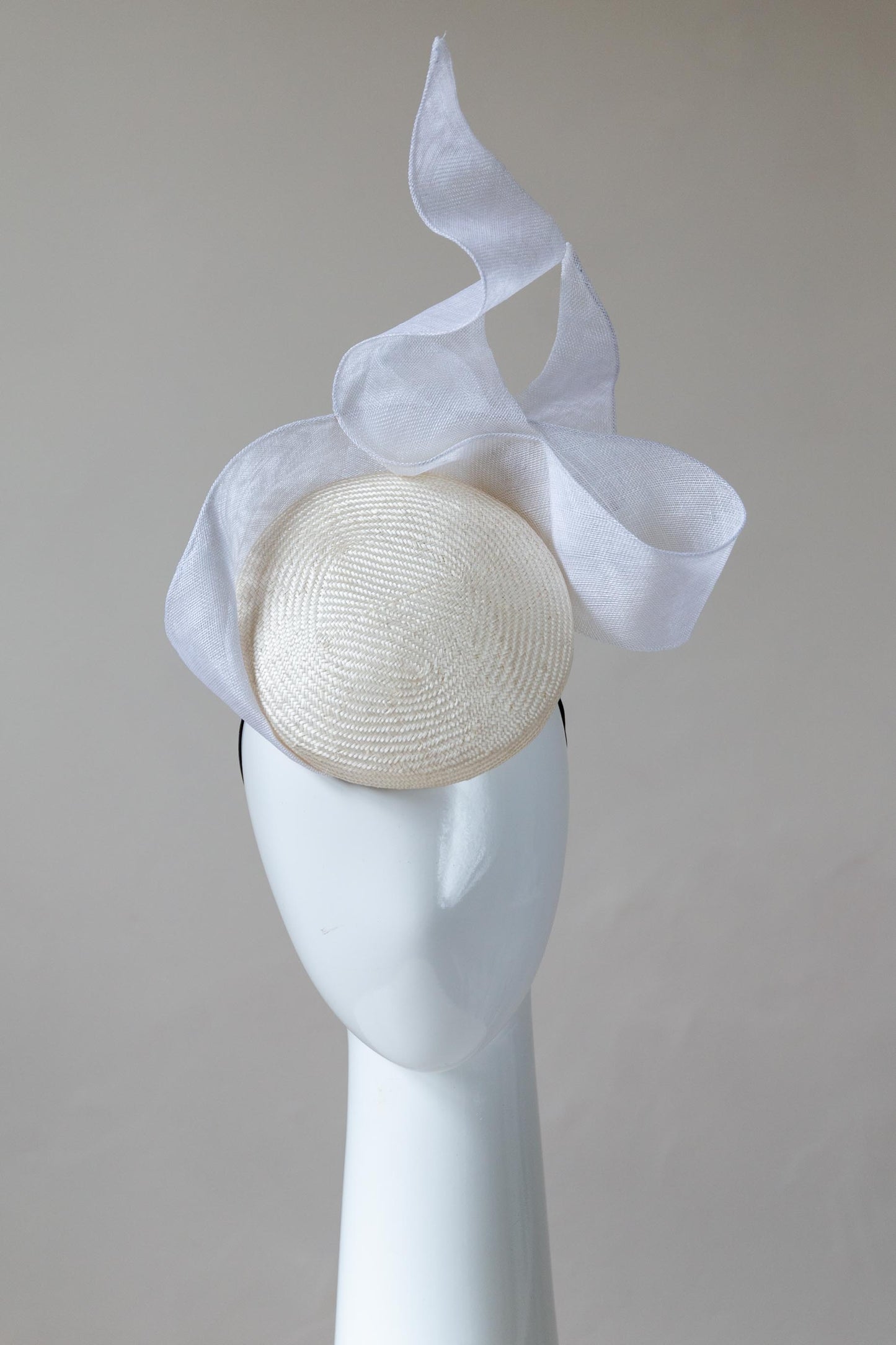 he Ivory and White Swirl Cocktail Hat is a beautiful, raised button beret in ivory straw and trimmed with a gorgeous white floating bow that adds lightness and height