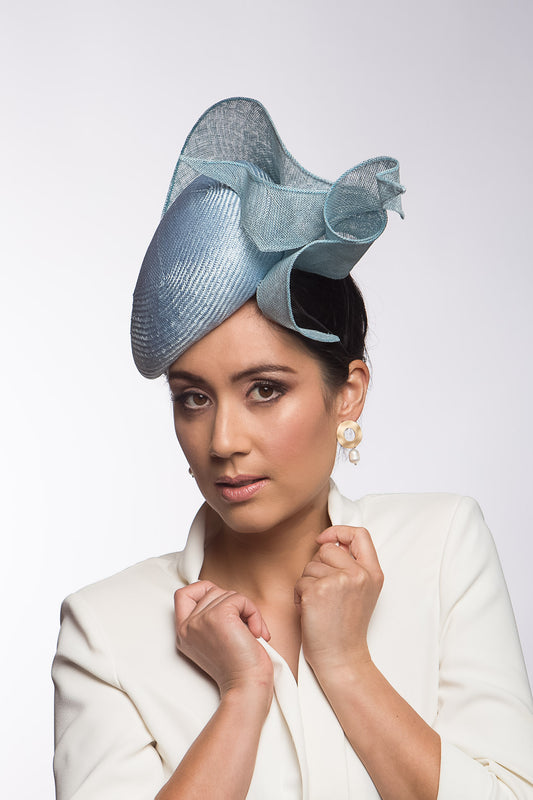 The Pale Blue Sculptured Beret style is an oval side beret Trimmed with curls of sinamay. Buy this millinery online or make an appointment to try it on