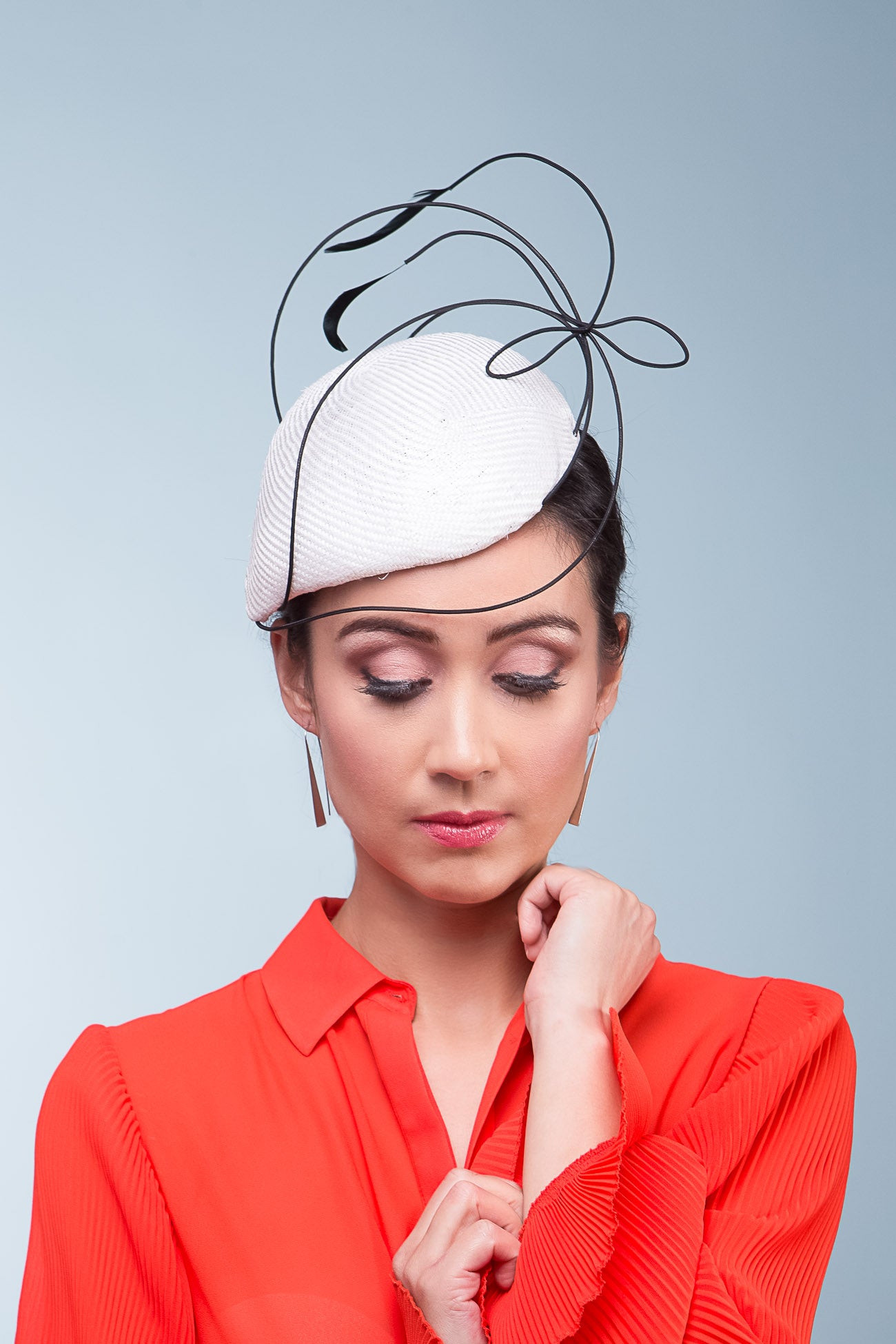 This Teardrop Derby Hat features a teardrop shaped side beret in white and trimmed with crinoline braid to create a sculptural effect