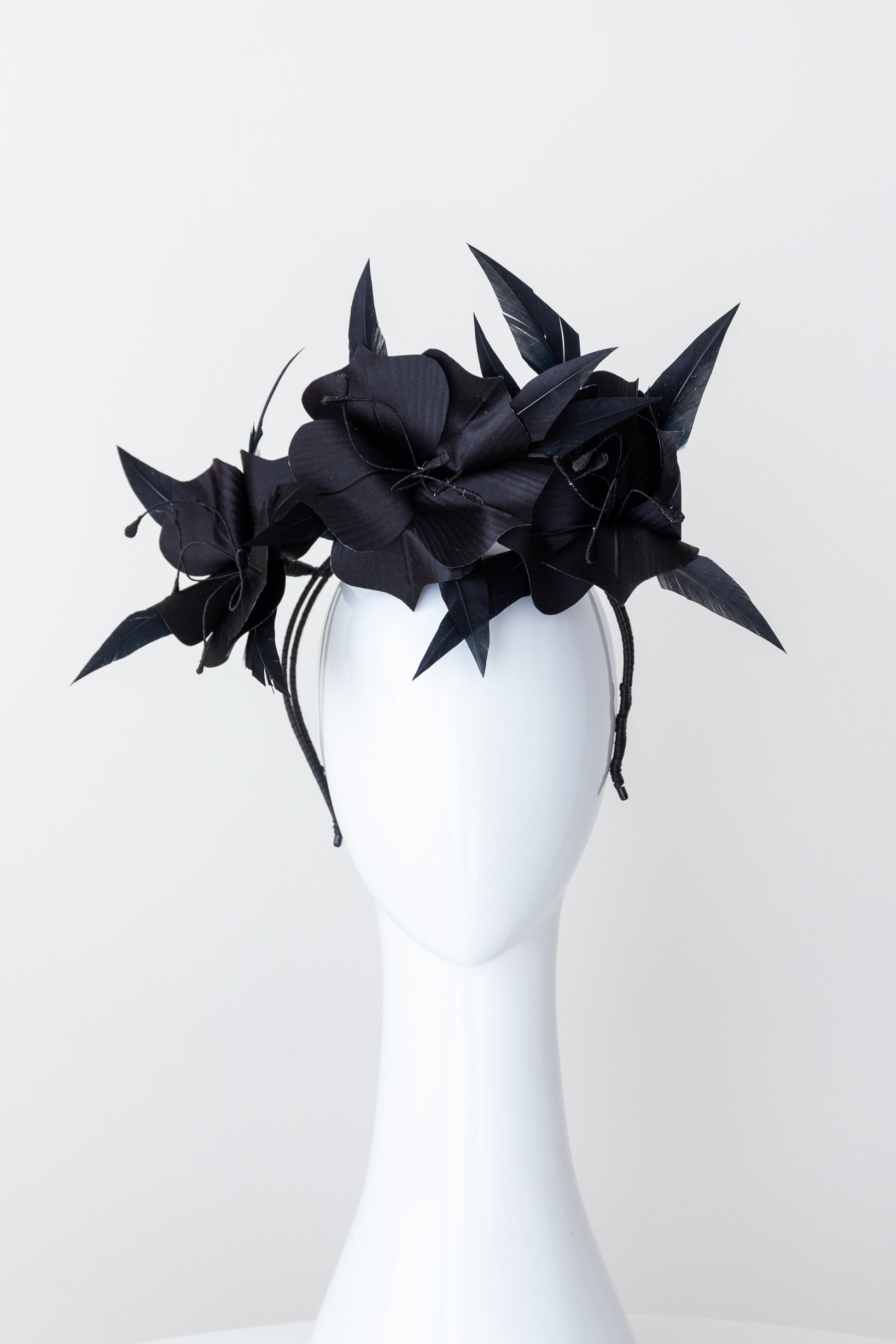 Trio of black silk flowers with feathers highlights