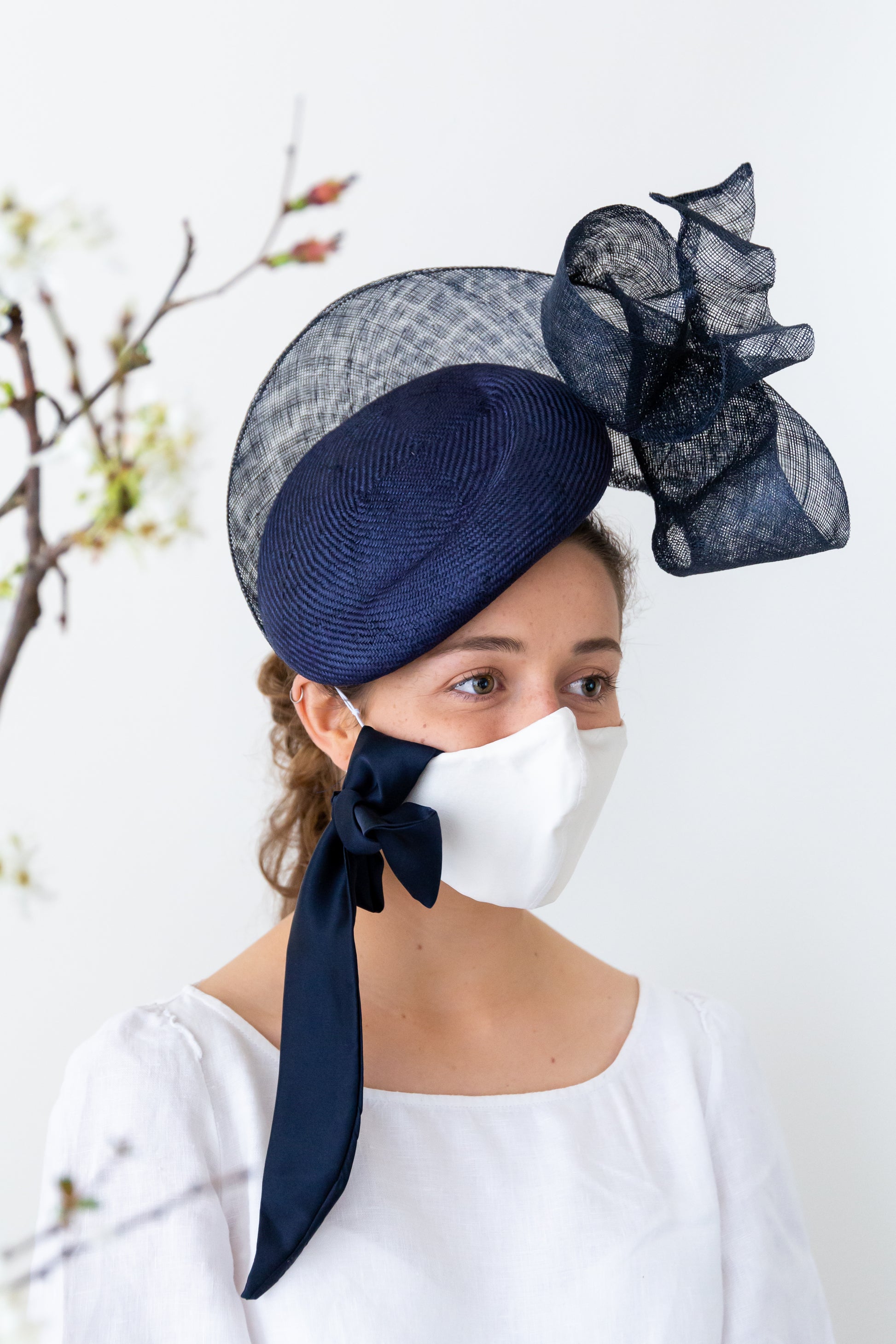white silk face mask and navy hat