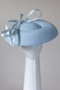 The Baby Blue Platter Hat with Sweeping Bows features a wide Dior brim with a shallow asymmetrical crown. Trimmed with lux satin silk bows on and under the brim