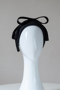 The Black Double Silk Bowed Headband features a raised close fitting straw headband with exquisite silk satin double bow