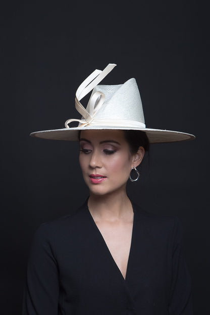 The Cream Fedora with Sweeping Bow is a modern fedora with a high angular concave crown and a sweeping wide brim