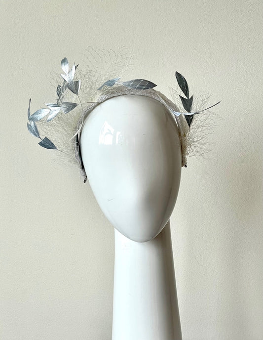 he Floating Silver Feather Swirls Headband has sculptured silver feathers that float in white veiling