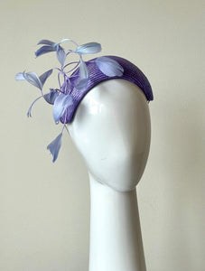 The headband is hand blocked in parisisal straw, trimmed with shaped dancing feathers feathers in lilac,purple and mauve.