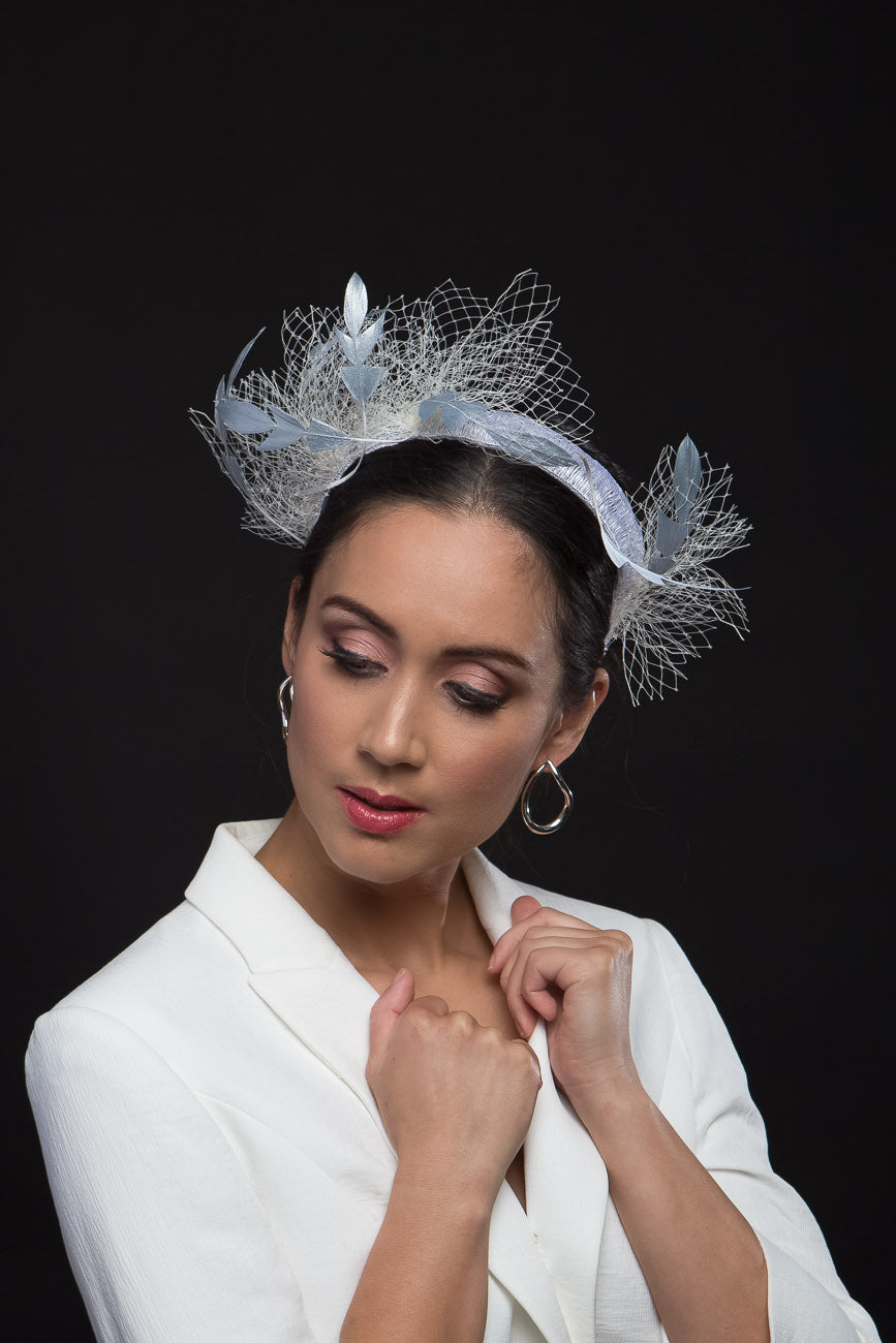 he Floating Silver Feather Swirls Headband has sculptured silver feathers that float in white veiling