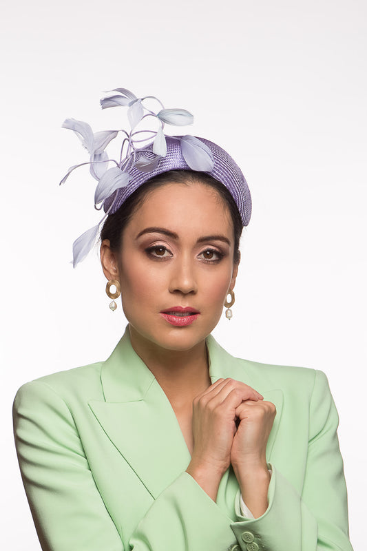 The headband is hand blocked in parisisal straw, trimmed with shaped dancing feathers feathers in lilac,purple and mauve.