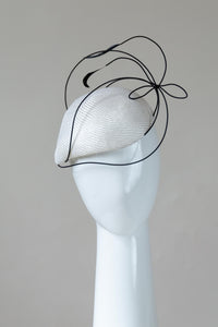 This Teardrop Derby Hat features a teardrop shaped side beret in white and trimmed with crinoline braid to create a sculptural effect