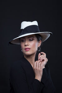 The White Panama Fedora with Black Trim is a modern fedora with a sweeping angular crown and features a wide brim which softly curves up.