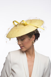 The Yellow Platter Hat with Bow and Veiling features a wide Dior brim with a shallow crown. Trimmed with a lux satin silk bow on across the brim and draped in a fine vintage veiling