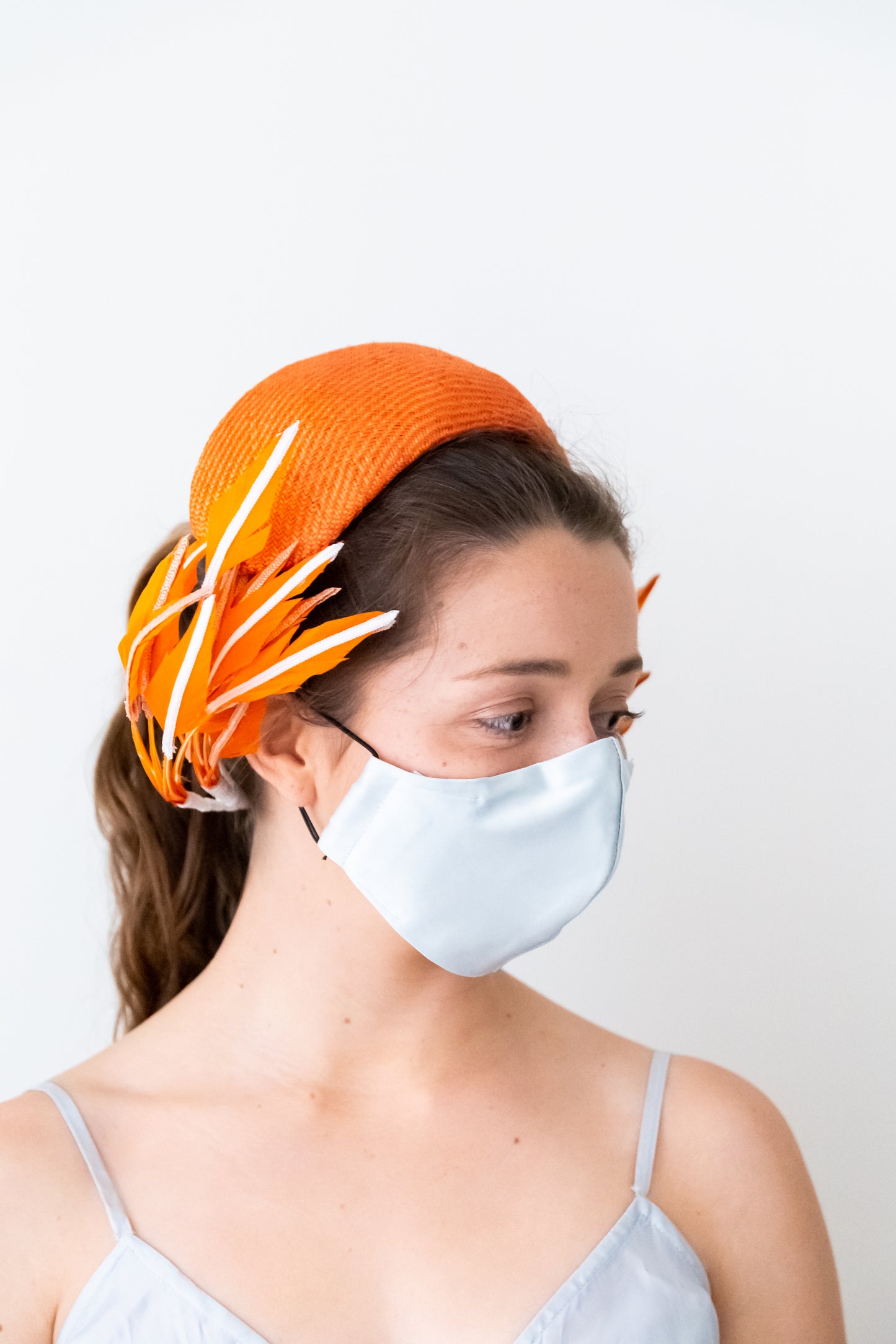 Orange bandeau with sweeping back feathers by Felicity Northeast Millinery